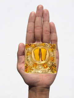 Lakshmi charan paduka brass finish held in hand, lotus-framed footprints