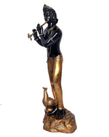 Black Krishna idol statue holding flute, brass and gold details on rounded base