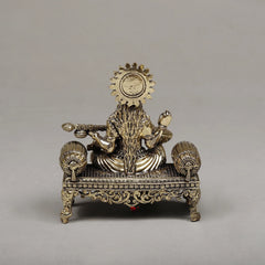 Brass Maa Saraswati seated sculpture from rear, detailed halo and ornate base legs