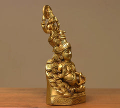 Brass Kuber–Laxmi sculpture angled view, seated form on base, halo above