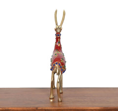 Back view brass reindeer statue with red enamel and blue jeweled details on gold legs