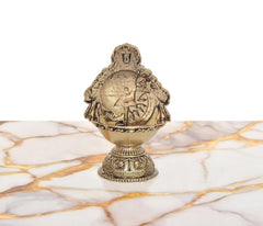 Brass oil lamp figurine with deity details on back and decorative round base