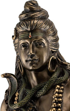 Shiva figurine close-up face, bronze-tone hair waves and small red tilak