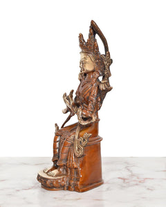 Side view of brass seated Tara Devi statue with crown halo and carved ornaments