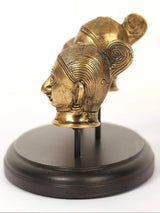Brass Parvati head idol side profile with detailed hair texture on dark base