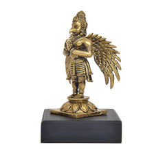 Side view of standing Garuda idol, gold-tone armor details, on dark base