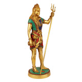 Brass standing Bholenath idol side view, tall trident, jeweled green and red outfit