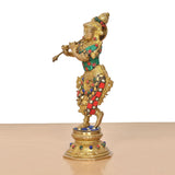 Side view of Krishna with flute, gold brass statue with colorful jeweled outfit