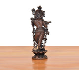 Copper-toned Krishna playing flute statue, back view on scalloped pedestal base.