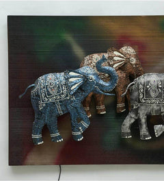 Close-up iron running elephants wall decor with LED lights, blue and gray elephants on panel