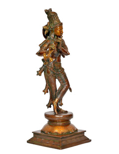 Brass Lord Krishna statue in profile, playing flute, ornate crown and robes, base