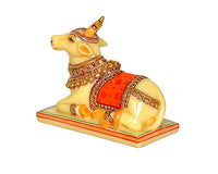 Resin Nandi cow idol three-quarter view, red saddle, gold beadwork, raised front leg
