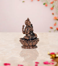 Copper Lakshmi idol, rear three-quarter view on lotus base with detailed ornaments
