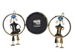 Back view of iron wall clock musician hanging: black center plate with two gold figure frames