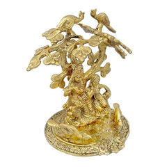 Gold-tone Radha Krishna statue under tree, side view with ornate birds and floral trim