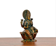 Lakshmi brass idol angled view, gold-toned face and teal-green torso on lotus seat