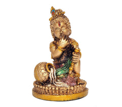 Resin Krishna idol standing on decorated round base, blue-green drape and gold details