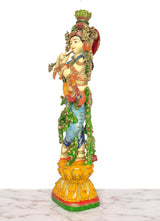 Krishna playing flute statue in profile, blue and green draped ornaments
