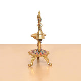 Brass peacock diya lamp rear view, vertical bell stem and multicolor base