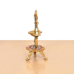 Brass peacock diya lamp rear view, vertical bell stem and multicolor base