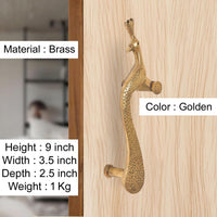 Brass peacock door handle, golden finish; mounted on light wood door surface