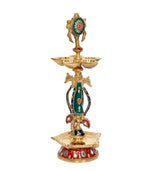 Brass chakra oil lamp diya with ornate green-red headpiece and three bowl top
