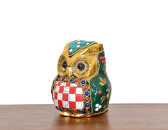 Metal owl statue side view, green body with leaf details and red-and-white checkered center