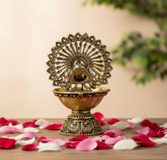 Brass peacock diya with fan crest, textured base and oil cup, 4-inch height