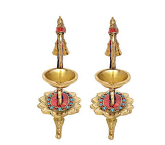 Front view: pair of brass bell diyas with central figures, two oil bowls and jeweled feet