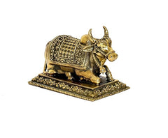 Brass Nandi cow idol side view with patterned saddle on base