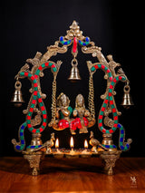 Radha Krishna statue on swing with lamps and diya, ornate gold frame, 36 cm height