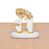 White resin Krishna hands with golden flute on round base, ornate peacock crown behind