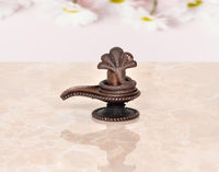 Copper Shiva ling figurine on round base with cobra hoods, side view