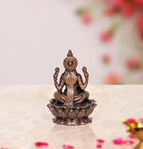 Copper Lakshmi idol statue back view, seated on lotus with ornate back details