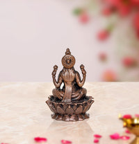 Copper Lakshmi idol statue back view, seated on lotus with ornate back details