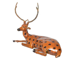 Brass sitting deer showpiece, front view of head with antlers and black-spotted body