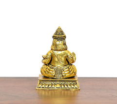 Gold Kuber idol brass statue, rear view, crowned head and ornamented back