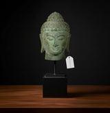 Bronze Buddha head idol on black stand, front face with serene expression