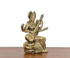 Brass Maa Saraswati statue angled view, holding veena and seated on lotus base