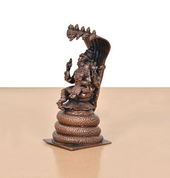 Side view of copper Lakshmi Narasimha idol under Sheshnag hood, on coiled base