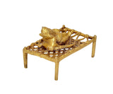 Brass Ganesha on charpai cot, three-quarter view, home pooja decor