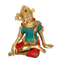 Indra brass idol close-up, seated hands on knees, teal outfit with red gold accents