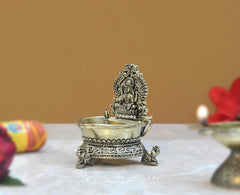 Brass Lakshmi oil lamp diya from side with detailed filigree and three feet