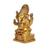 Golden brass Ganesh statue, front view, trunk curl, detailed crown and ornaments