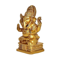 Golden brass Ganesh statue, front view, trunk curl, detailed crown and ornaments