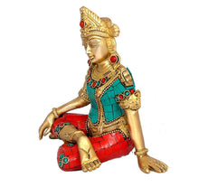 Indra brass idol side profile, seated figure with teal garment and red jeweled accents