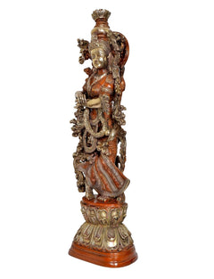Side view of Radha Rani brass idol statue with carved ornaments and draped robe