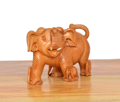 Wooden elephant showpiece from front-left, brown carved face with tusks and ears