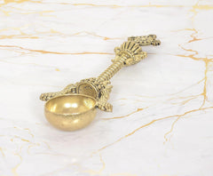 Bronze Achmani Patra spoon with ornate end pieces and bowl facing camera