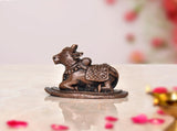Copper Nandi cow idol statue on base, seated with ornate saddle details